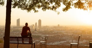 Man in a park looking at a city