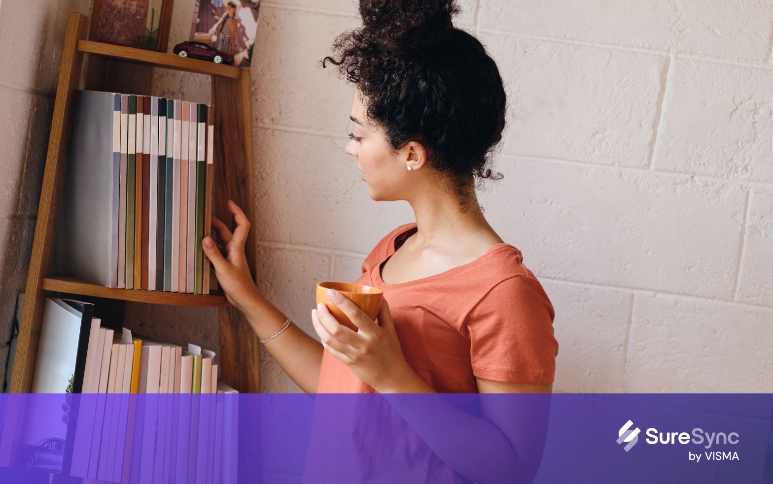 Young  woman in casual outfit taking textbook from bookcase  in library of modern university