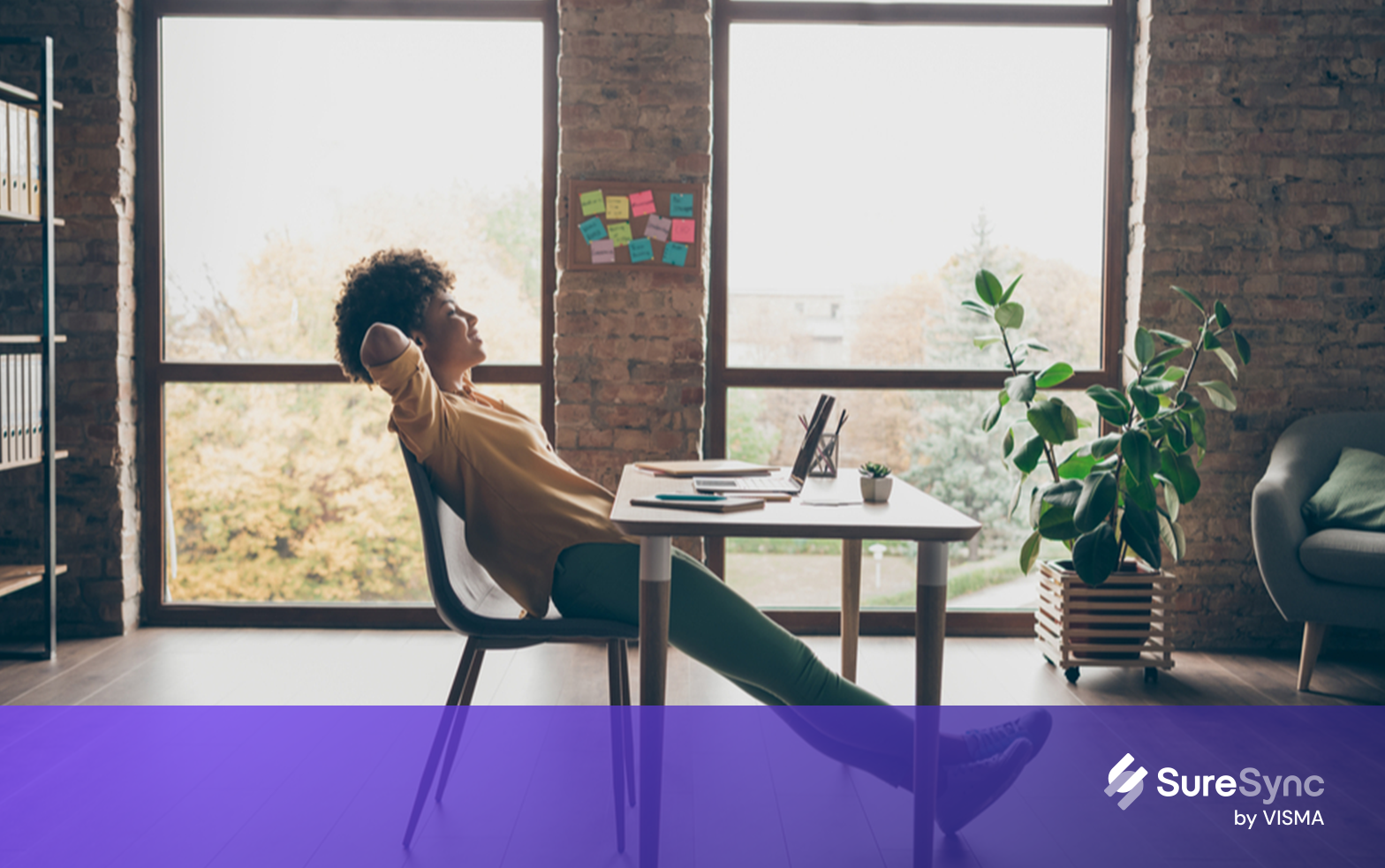 women laying on chair and checking her laptop