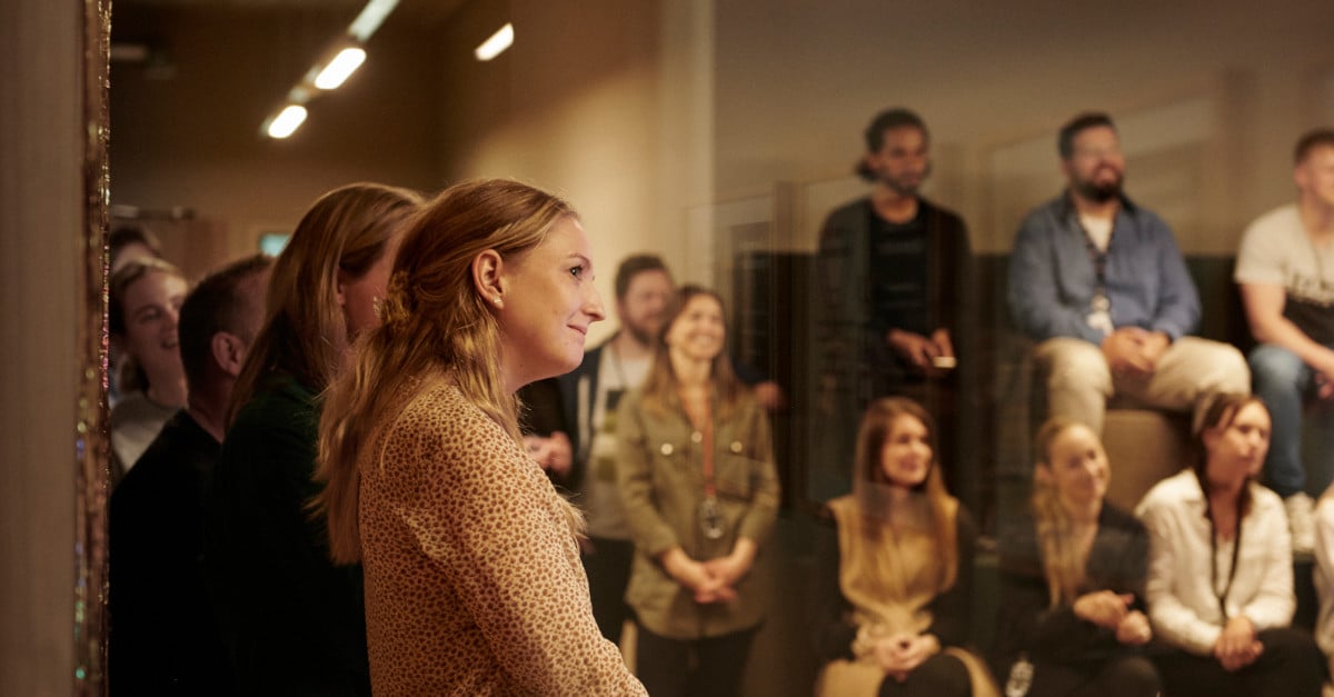Group of people celebrating and listening to speaker at an office